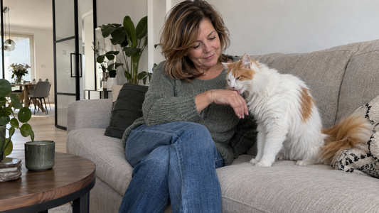 Turkse Van likt rustig de hand van een vrouw op de bank